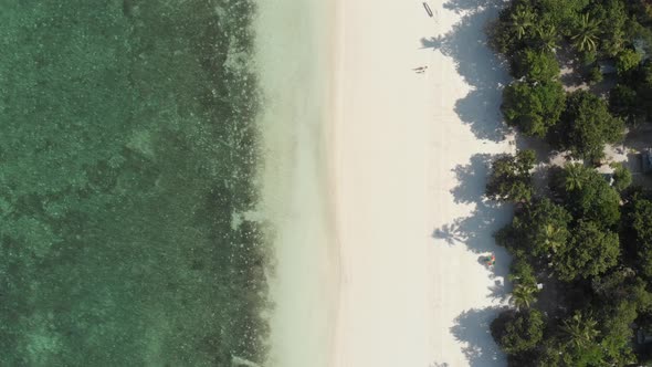 Aerial: flying over white sand beach tropical sea Kei Islands Indonesia