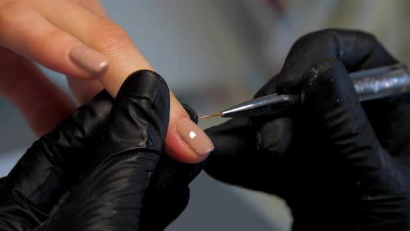 Professional Manicurist Applies Gel on Visitor Fingernail