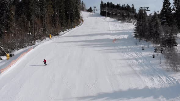 Aerial View of Skiers Go Down Ski Slopes Near Ski Lifts on Ski Resort. Bukovel