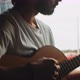 Young man playing the guitar sitting in the back of a van - VideoHive Item for Sale