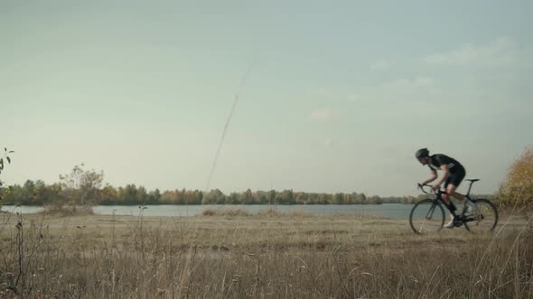 Cyclist Riding On Carbon Bike In Lycra Sportswear. Muscular Fitness Biker Cycling Workout.