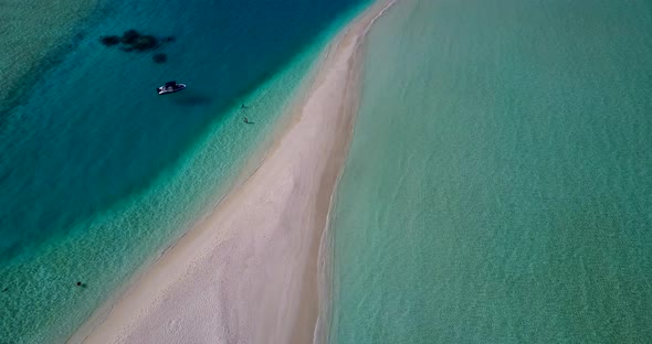 Tropical overhead abstract shot of a white sandy paradise beach and blue ocean background in vibrant