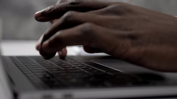Close Up Hands African American Man Doctor Typing on Keyboard Laptop in Clinic
