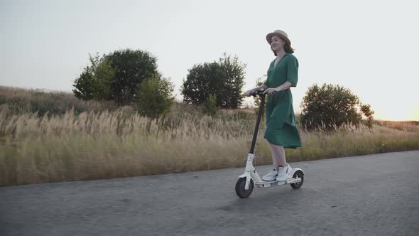 Happy Young Couple Enjoying Together While Riding on Electric Scooters on Road