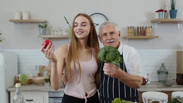 Senior Grandfather with Granddaughter Recommending Eating Raw Vegetable Food. Vegetable Diet