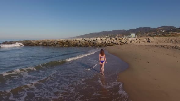 Woman Walking On The Beach