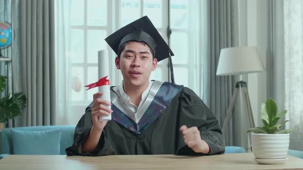 Asian Man Celebrating With University Certificate During An Online Video Call At Home