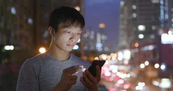 Asian Man Use of Mobile Phone in City at Night