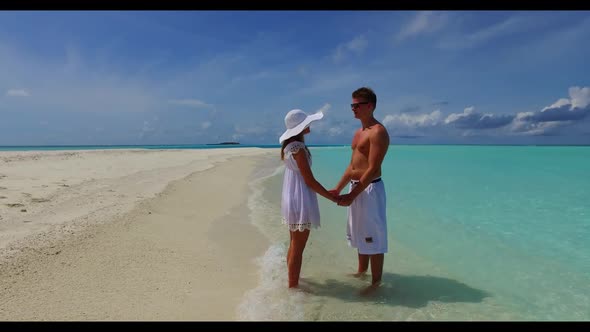 Man and lady posing on relaxing island beach time by blue sea with white sandy background of the Mal