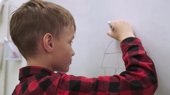 Boy Pupil Draws on the Chalkboard While Studying at School