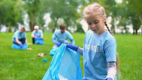 Responsible Child Volunteer Collecting Trash in Garbage Bag Smiling on Camera