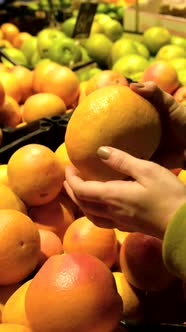 Woman Choosing Grapefruit in Store