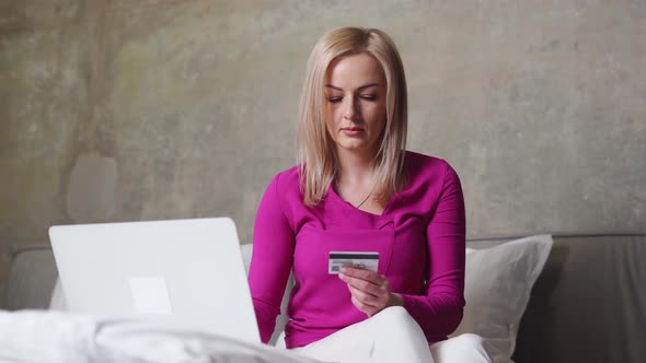 Caucasian Beautiful Woman on the Bed with Laptop and Credit Card