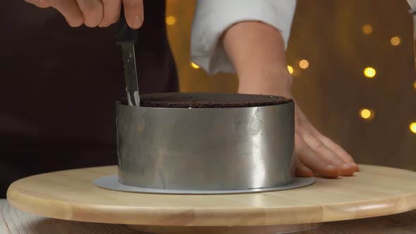 Closeup of the Chef Removing a Metal Ring Mold From a Carrot Cake with Caramel