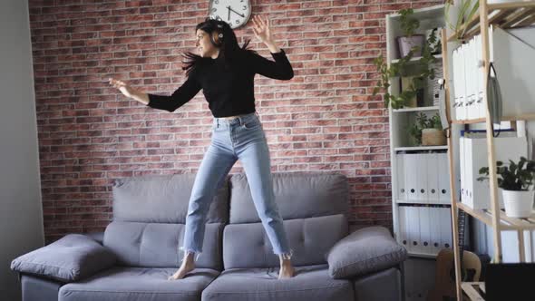 woman dancing on a couch in her house