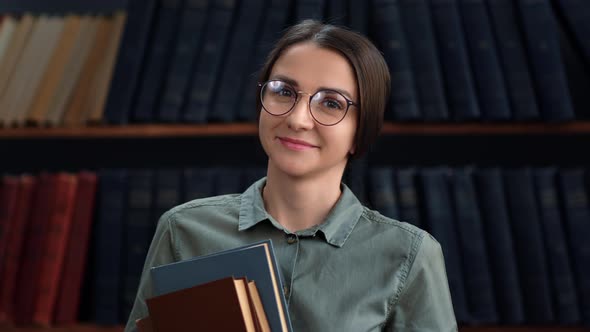 Adorable Beauty Woman Teacher Student Posing with Stack Paper Books at Vintage Library Bookshelves alt