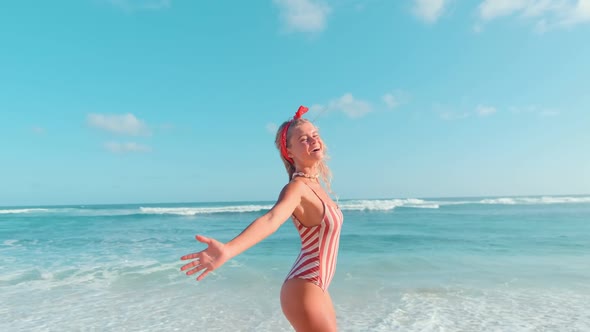 Young Caucasian Woman Spinning Around Herself Going Into Ocean Washing Beach