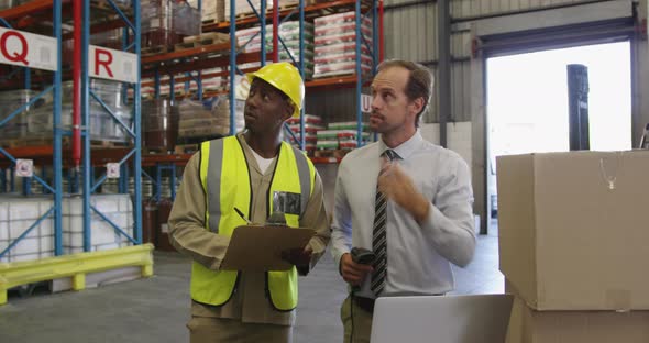 Male warehouse manager and warehouse worker in loading bay 4k