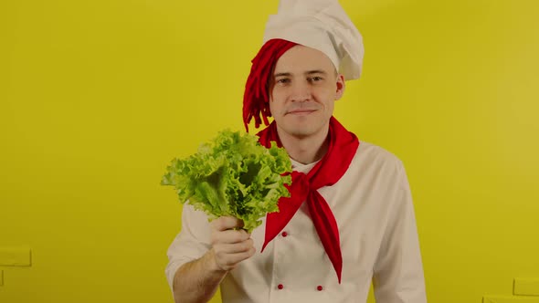 Man with Red Dreadlocks Holds Lettuce Leaves