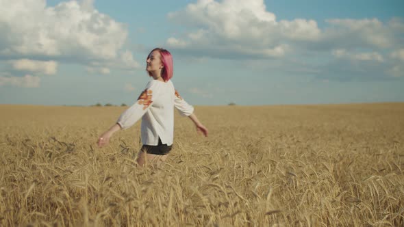 Excited Female Spinning Around in Wheat Field