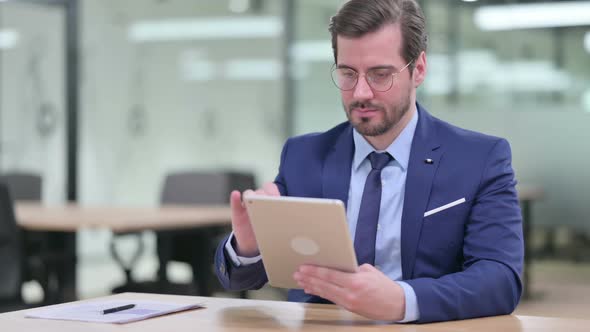 Serious Professional Young Businessman Using Tablet