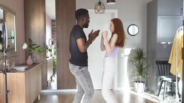 Lovely Young Multiethnic Couple Dance in Living Room