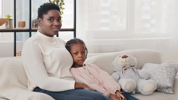 Afro American Family Smiling Young Mother Woman Nanny Mom and Serious Little Girl Daughter Child Kid