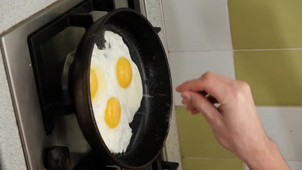 Vertical Video Young Man Preparing Scrambled Eggs Frying Pan Home Kitchen