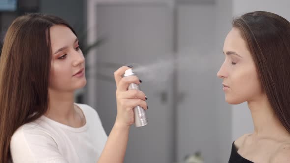 Brunette Makeup Artist Using Spray in Beauty Salon