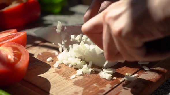 Person Slicing White Onion In Small Dice. - close up