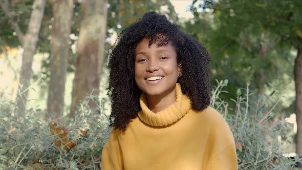 Portrait of a Smiling Brazilian Woman with Curly Hair Looking at Camera