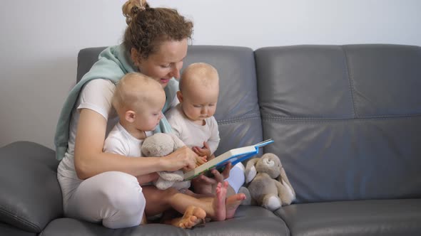 Happy Mother Reading Book To Her Twin Babies