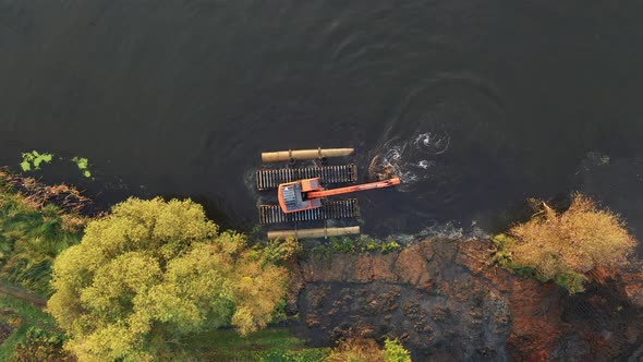 Bulldozer on the river performs dredging. River reclamation.