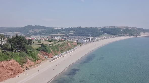 Sky view while zooming out over the ocean and beach of east Devon, Seaton in England. The beautiful