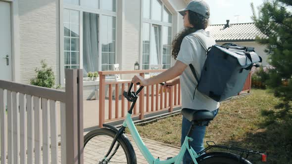 Delivery Worker Girl with Backpack Riding Bicycle Then Knocking on Customer's Door