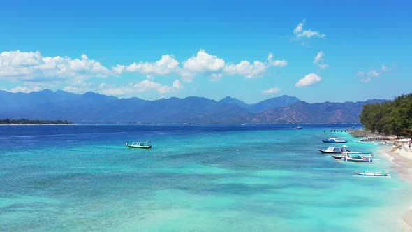 Wide angle birds eye abstract shot of a white sandy paradise beach and blue ocean background