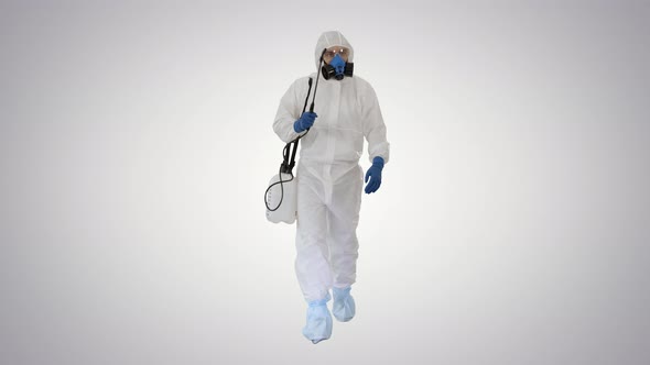 Virologist in Protective Uniform Walking and Disinfecting the Area on Gradient Background.