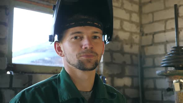 Mechanic Smiling and Looking at Camera. Portrait of Happy Man with Beard Working in His Garage or