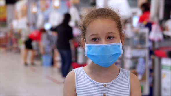 Little Girl Child in a Mask From Viruses of the Epidemic of the Coronavirus or Viruses Looks at the