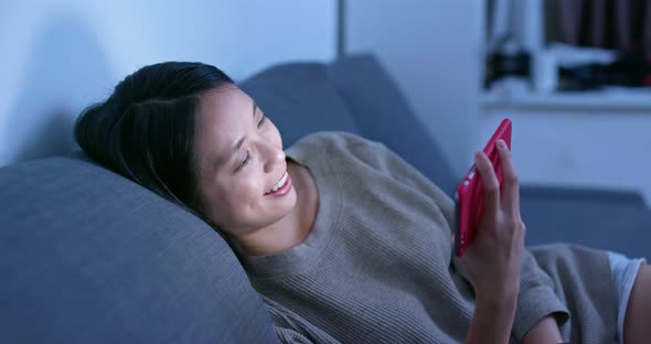 Woman work on cellphone at home in the evening