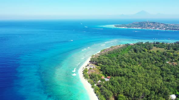 Wide drone island view of a summer white paradise sand beach and blue sea background in 4K