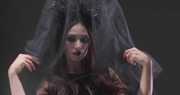 Mystical Girl in Black Veil Looking at the Camera and Smiles, the Celebration of Halloween, Portrait