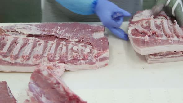 Butcher Who Cuts Meat In A Meat Processing Factory