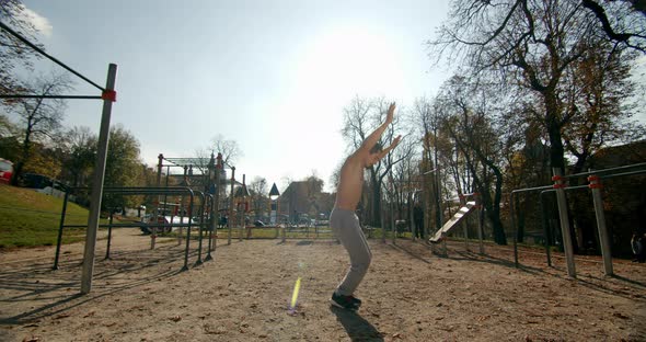 A Man Is Doing a Burpee on the Sports Area in Good Weather 