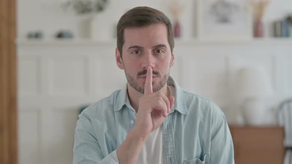 Young Man Putting Fingers on Lips Quiet Sign