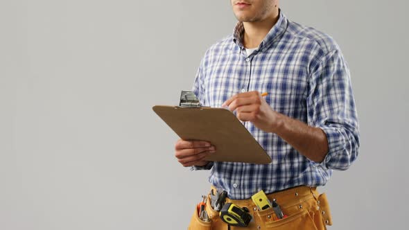 Male architect writing on clipboard