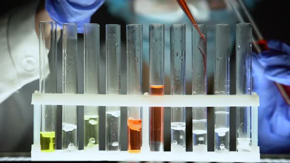 Chemist Pouring Red Liquid in Test Tubes and Checking Reaction, Fake Medication