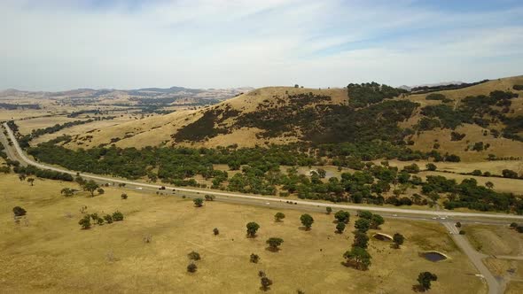 Stunning aerial view of golden Australian landscape including natural features and impressive road n