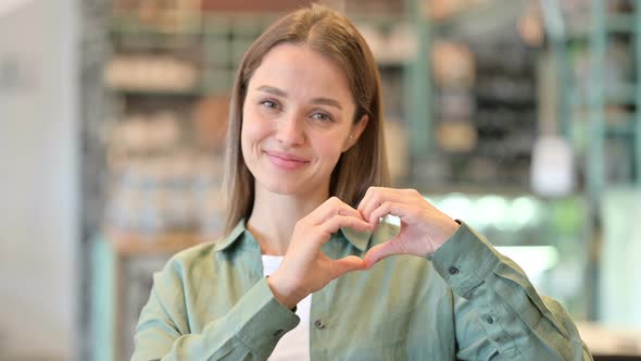 Portrait of Woman Showing Heart Sign with Hand