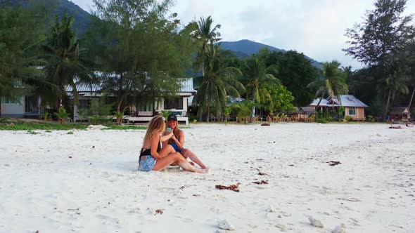 Girls tanning on tropical coast beach voyage by clear lagoon with white sandy background of Koh Phan